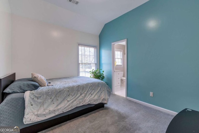 carpeted bedroom featuring ensuite bathroom and vaulted ceiling