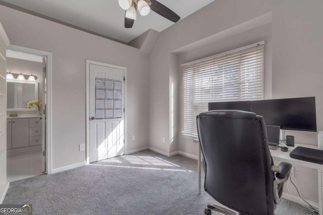 office area featuring lofted ceiling, light carpet, and ceiling fan