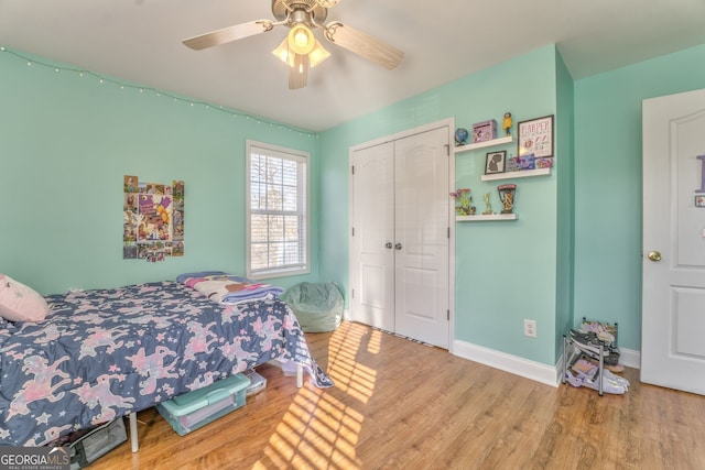 bedroom with ceiling fan, a closet, and hardwood / wood-style flooring