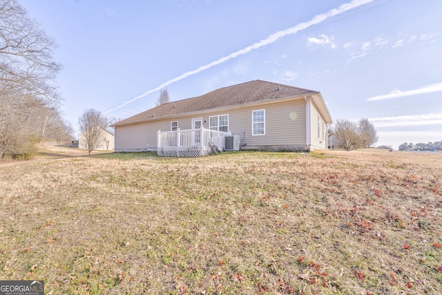 rear view of house featuring central AC unit, a deck, and a lawn