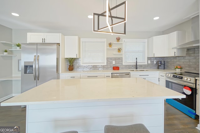 kitchen featuring appliances with stainless steel finishes, white cabinets, decorative light fixtures, and sink