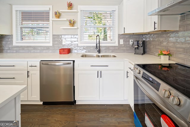 kitchen with sink, dark wood-type flooring, appliances with stainless steel finishes, and white cabinetry