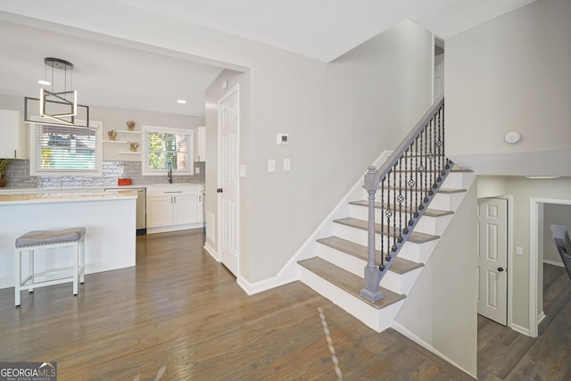 stairway featuring wood-type flooring and sink