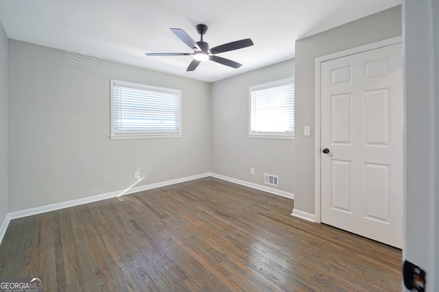 unfurnished room featuring ceiling fan and dark wood-type flooring