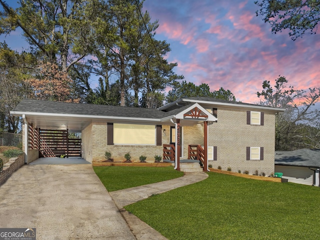 view of front of home with a yard, a carport, and covered porch