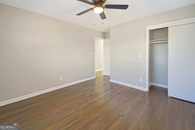 unfurnished bedroom with dark hardwood / wood-style flooring, a closet, and ceiling fan