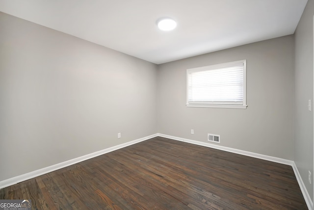 spare room with dark wood-type flooring