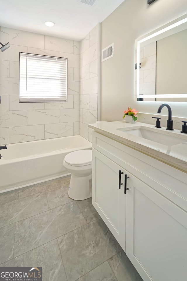 full bathroom featuring toilet, vanity, and tiled shower / bath