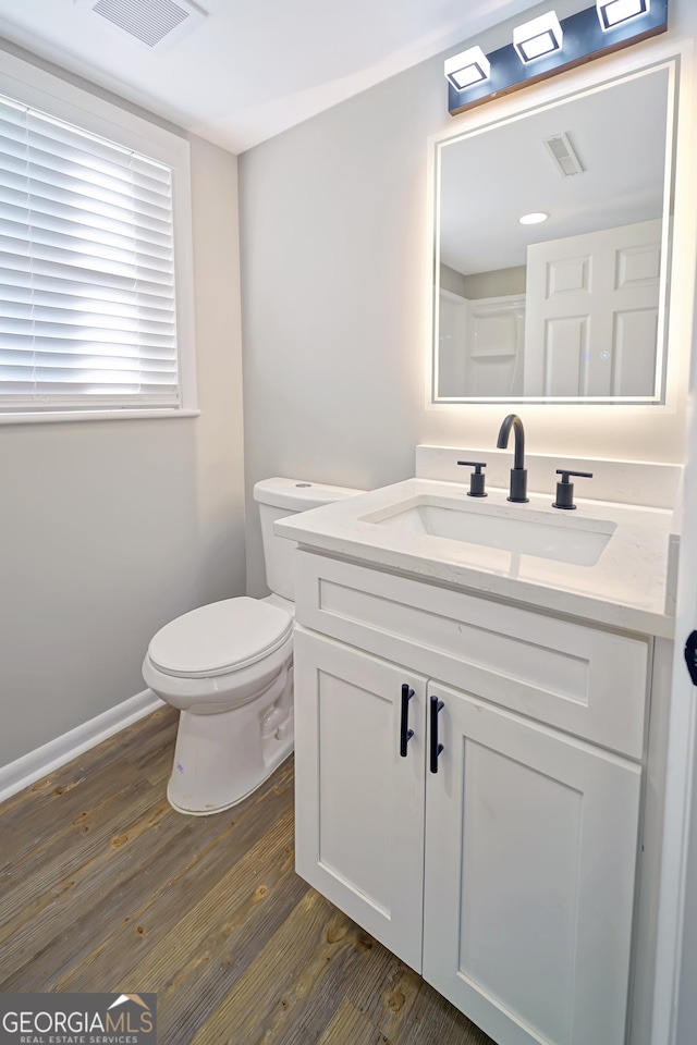 bathroom featuring toilet, hardwood / wood-style flooring, and vanity