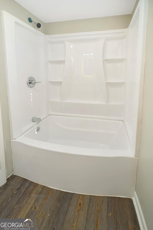 bathroom with bathing tub / shower combination and hardwood / wood-style floors