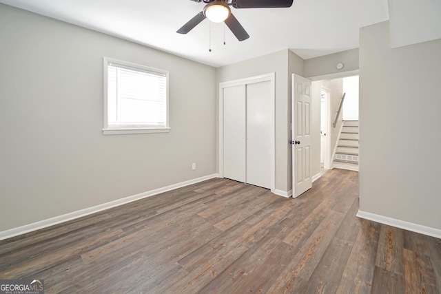 unfurnished bedroom featuring ceiling fan, a closet, and dark hardwood / wood-style floors