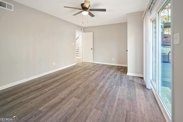 empty room with ceiling fan and dark wood-type flooring