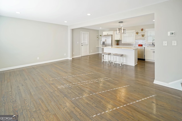 unfurnished living room featuring sink and dark hardwood / wood-style floors