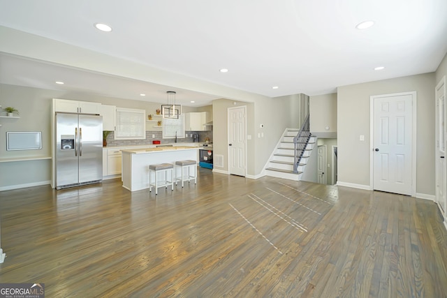 unfurnished living room featuring sink and dark hardwood / wood-style floors