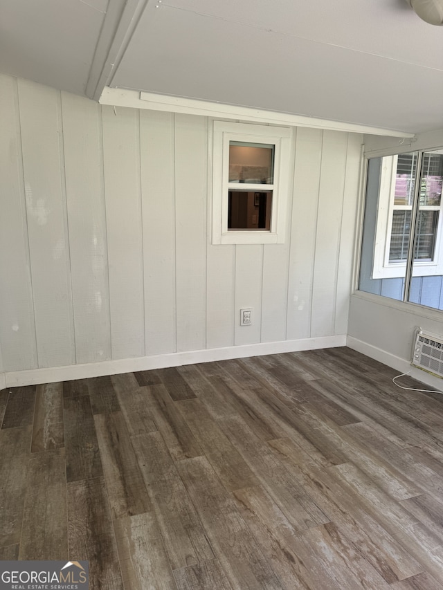 spare room featuring hardwood / wood-style flooring and an AC wall unit