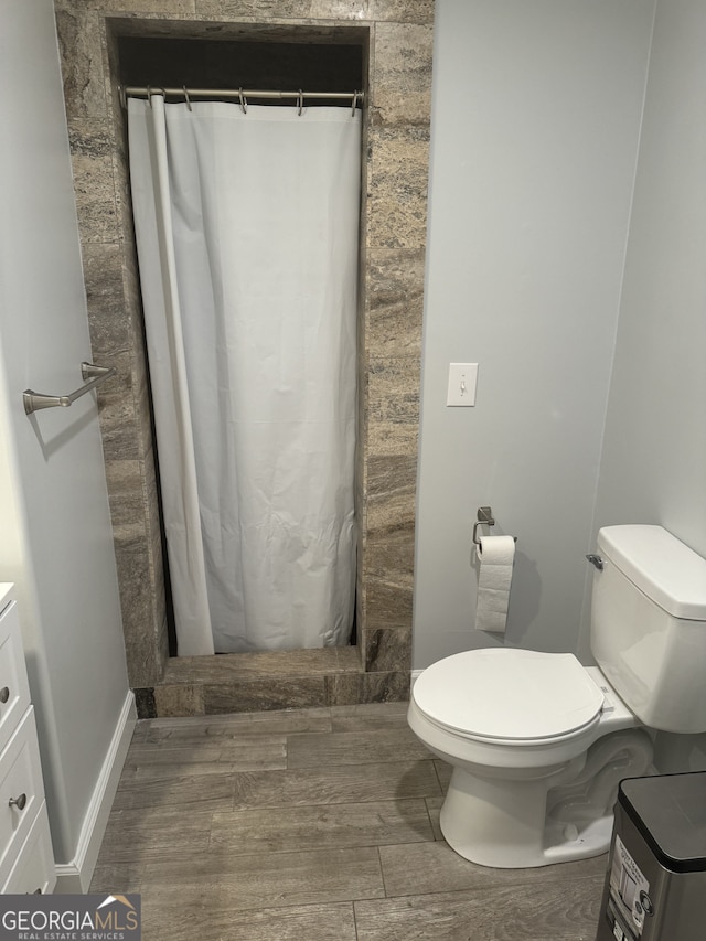 bathroom with toilet, vanity, and a shower with curtain