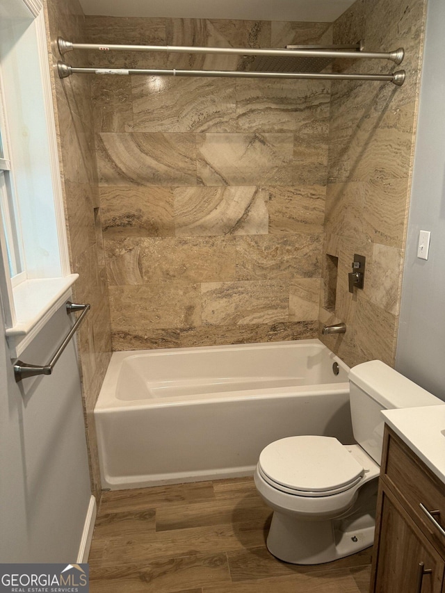 full bathroom with tiled shower / bath combo, hardwood / wood-style floors, toilet, and vanity