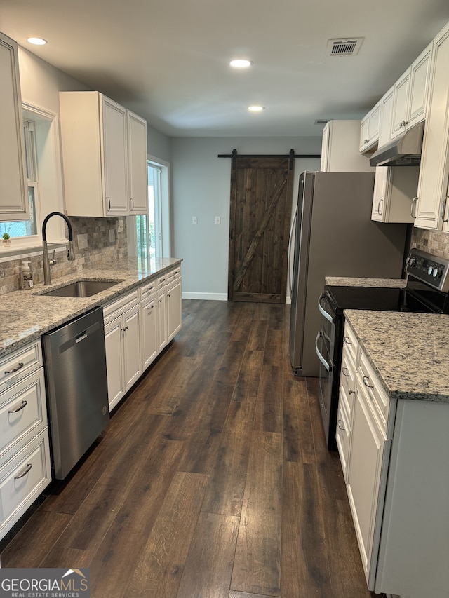 kitchen with light stone countertops, sink, white cabinets, and appliances with stainless steel finishes