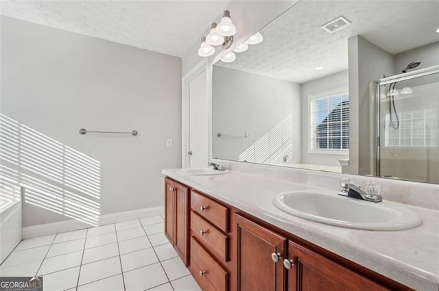 bathroom featuring a textured ceiling, plus walk in shower, tile patterned floors, and vanity