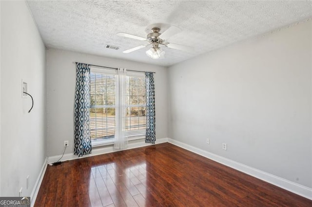 empty room with ceiling fan, hardwood / wood-style floors, and a textured ceiling