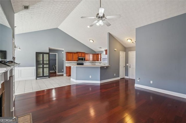 unfurnished living room with lofted ceiling, ceiling fan, and light hardwood / wood-style floors