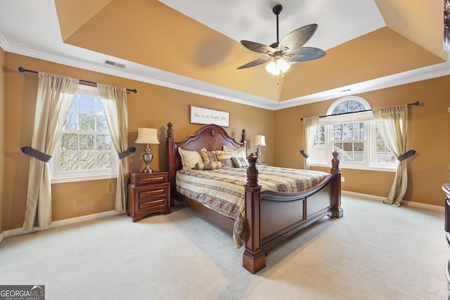 carpeted bedroom featuring ceiling fan, ornamental molding, and a tray ceiling