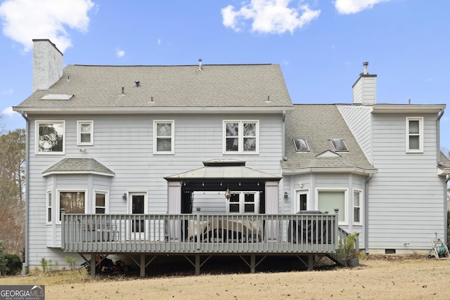 rear view of property featuring a gazebo and a wooden deck