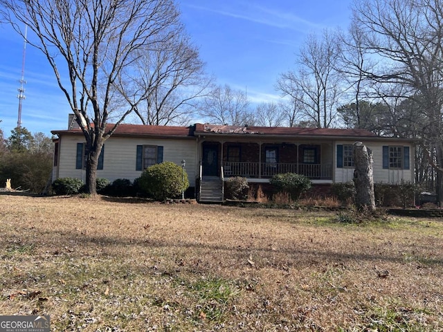 ranch-style home with a front yard and covered porch