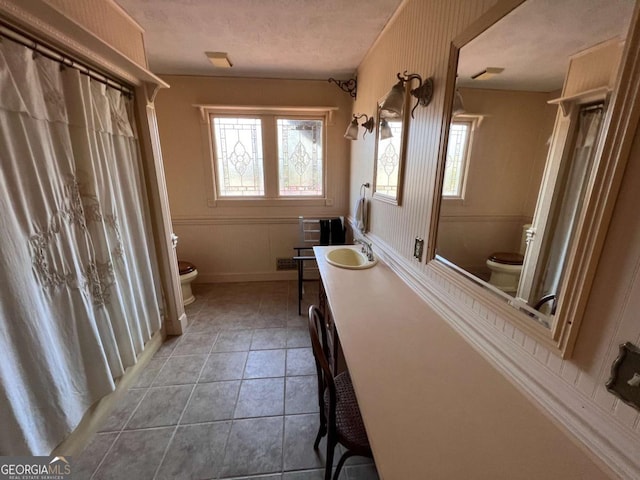 bathroom with tile patterned flooring, a wealth of natural light, and toilet