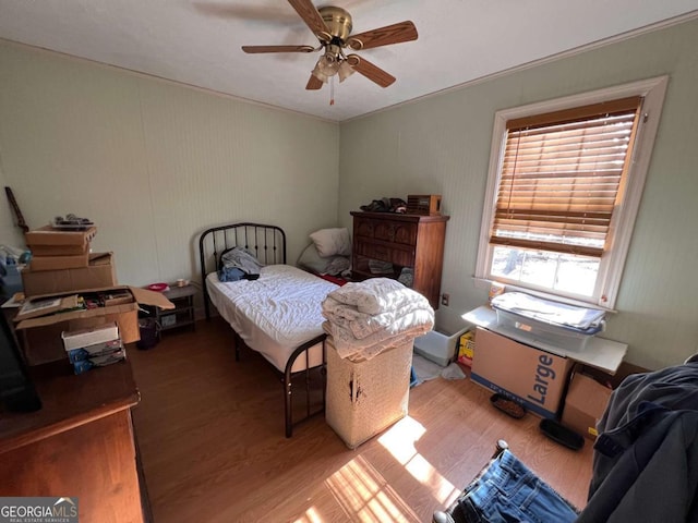 bedroom with hardwood / wood-style flooring, ceiling fan, crown molding, and multiple windows