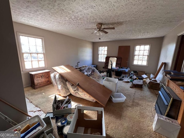 interior space featuring a textured ceiling, ceiling fan, and carpet flooring