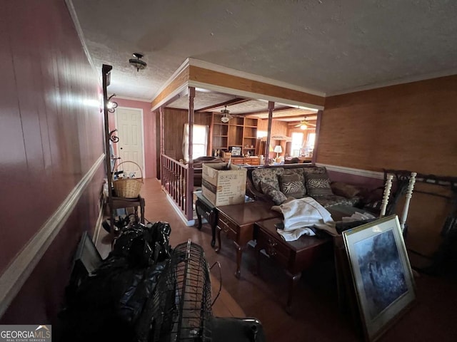 misc room with a textured ceiling, ornamental molding, and wood walls