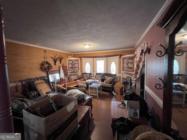 living room with a textured ceiling, ornamental molding, and hardwood / wood-style floors