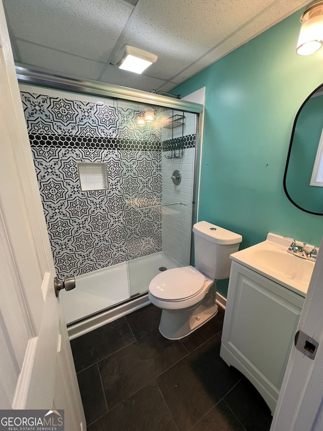 bathroom with an enclosed shower, vanity, tile patterned flooring, and toilet