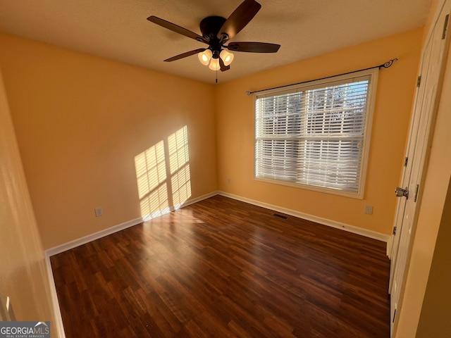 empty room with dark hardwood / wood-style floors and ceiling fan