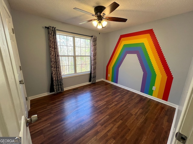 unfurnished bedroom with ceiling fan, dark hardwood / wood-style floors, and a textured ceiling