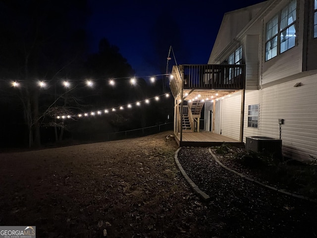 yard at twilight featuring a wooden deck and central AC