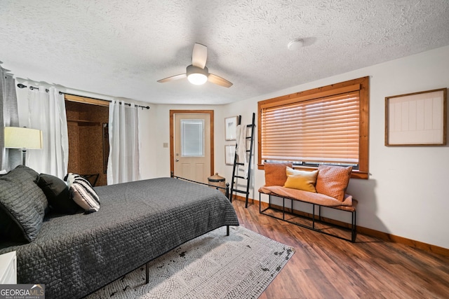 bedroom featuring a textured ceiling, ceiling fan, and dark hardwood / wood-style floors