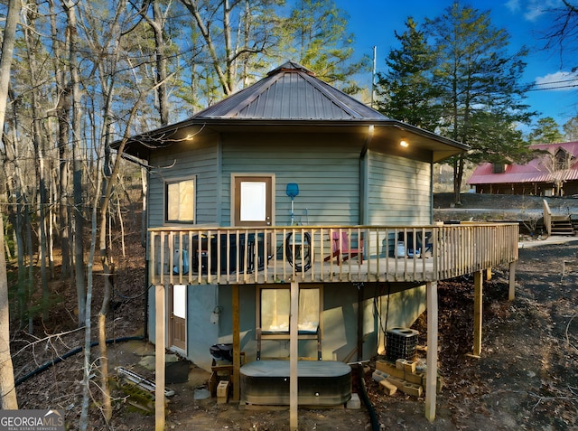 rear view of property featuring a wooden deck and central air condition unit