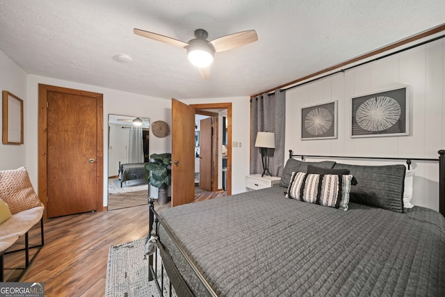 bedroom featuring a textured ceiling, ceiling fan, and hardwood / wood-style flooring