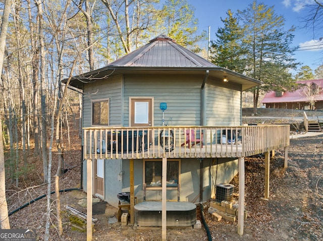 rear view of house featuring central AC and a wooden deck