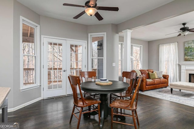 dining room with decorative columns, french doors, ceiling fan, and dark hardwood / wood-style floors