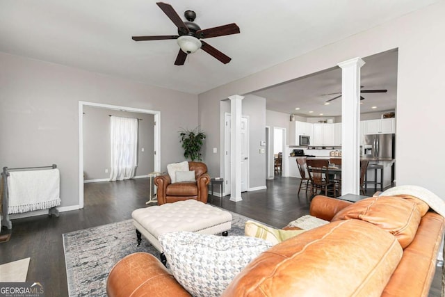 living room featuring decorative columns, ceiling fan, and dark hardwood / wood-style floors