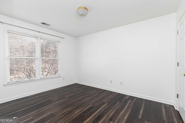 spare room with dark wood-type flooring