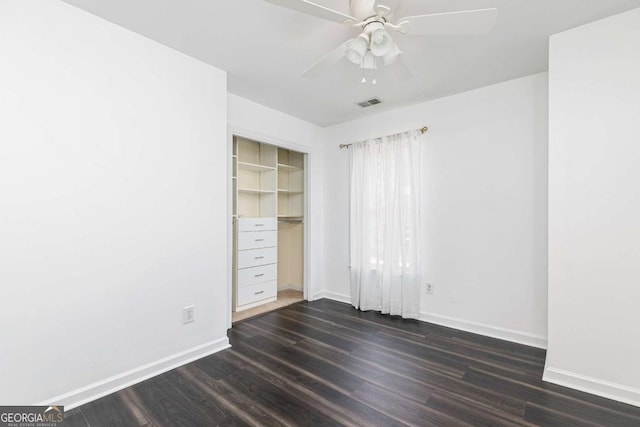 unfurnished bedroom with ceiling fan, dark hardwood / wood-style flooring, and a closet