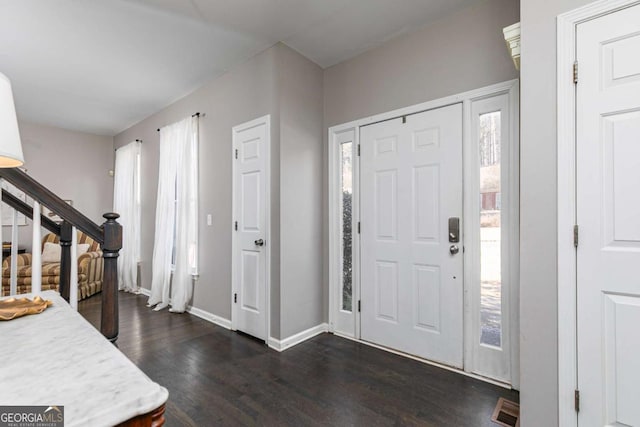 foyer entrance featuring a healthy amount of sunlight and dark hardwood / wood-style floors