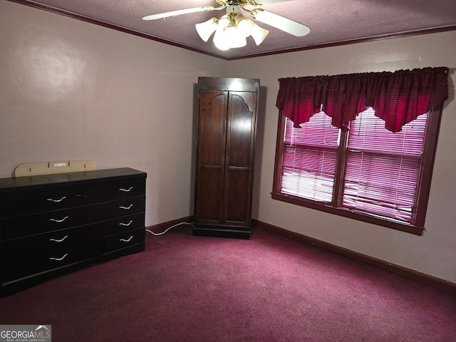 bedroom with ceiling fan, ornamental molding, a textured ceiling, and dark colored carpet