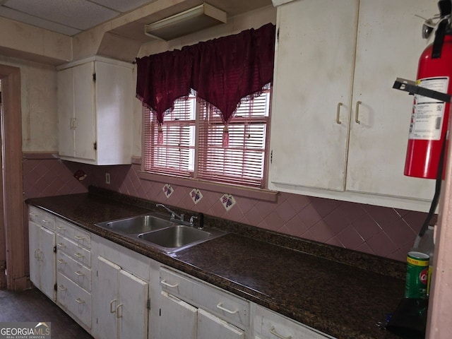 kitchen with tasteful backsplash, white cabinetry, and sink