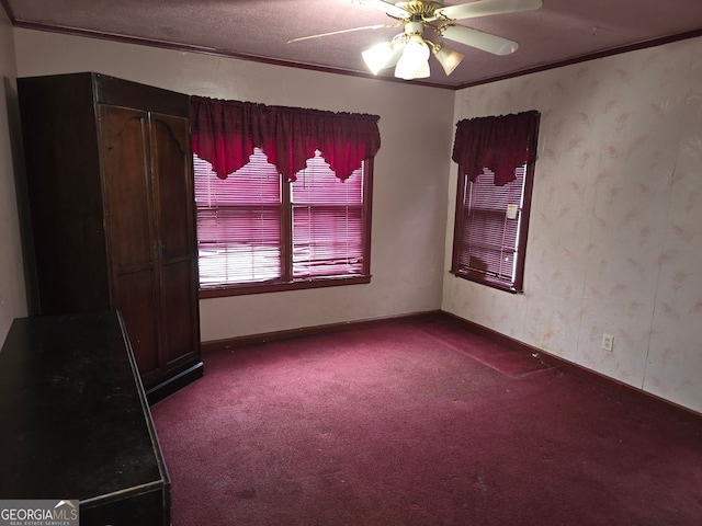 carpeted empty room featuring crown molding, ceiling fan, and a textured ceiling