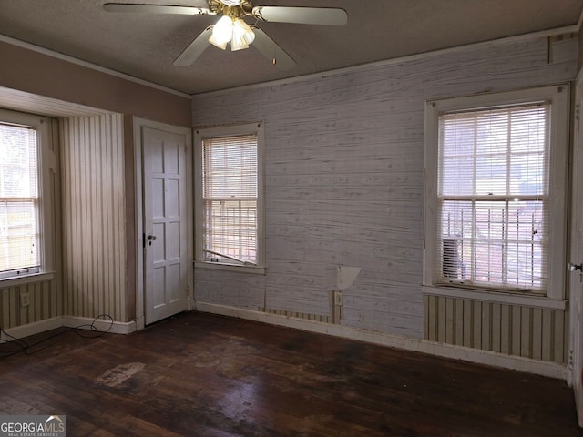 empty room with ornamental molding, dark hardwood / wood-style floors, and ceiling fan